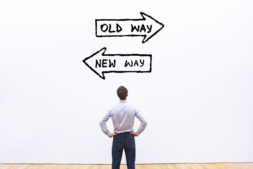 Man looking at two choices - old way and new way