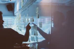 person presenting a strategy on a whiteboard with post it notes